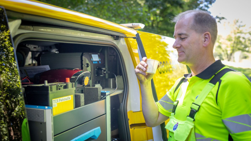 TCS Patrouillenmitarbeiter am Servicefahrzeug mit mobiler Lade- und Diagnosetechnik.