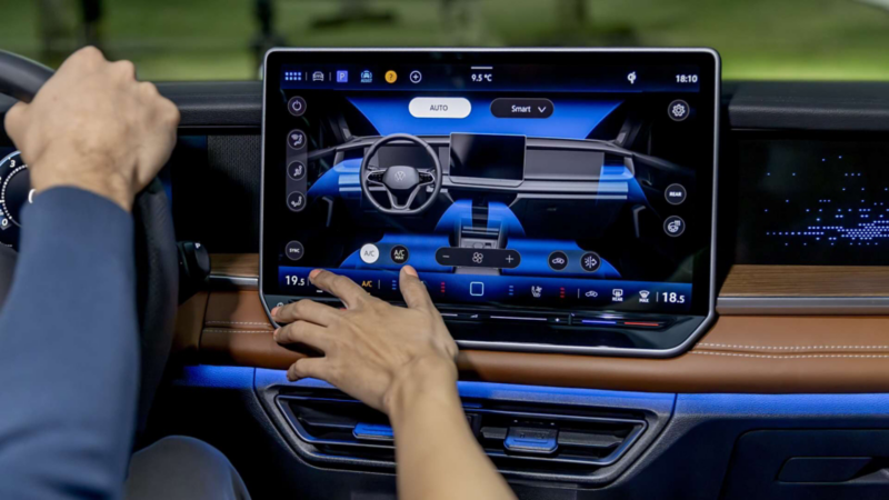 Mujer toca la pantalla flotante de Nuevo Tiguan 2025 que muestra cámara 360.