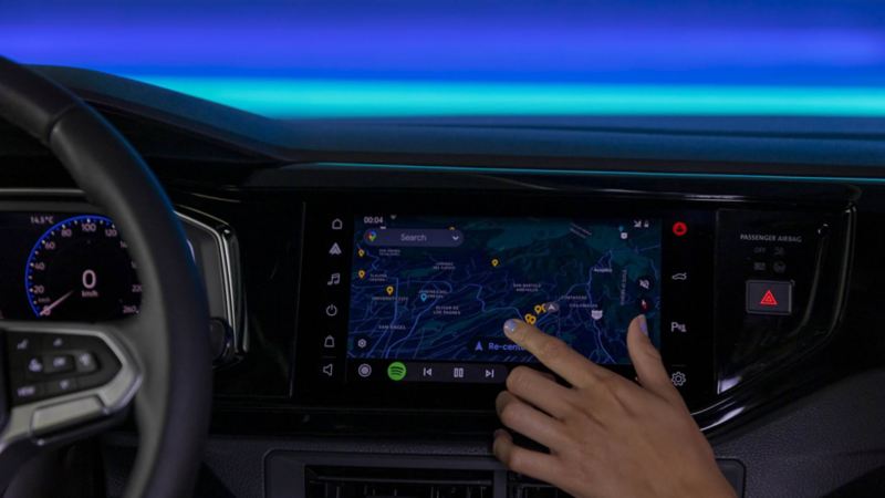 Mano de copiloto de Nivus 2023 toca pantalla touch que muestra un mapa. 