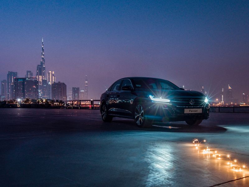 The 2020 Volkswagen Passat parked outside a city, a row of lights lay on the floor in front of it