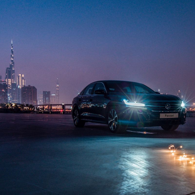 The 2020 Volkswagen Passat parked outside a city, a row of lights lay on the floor in front of it