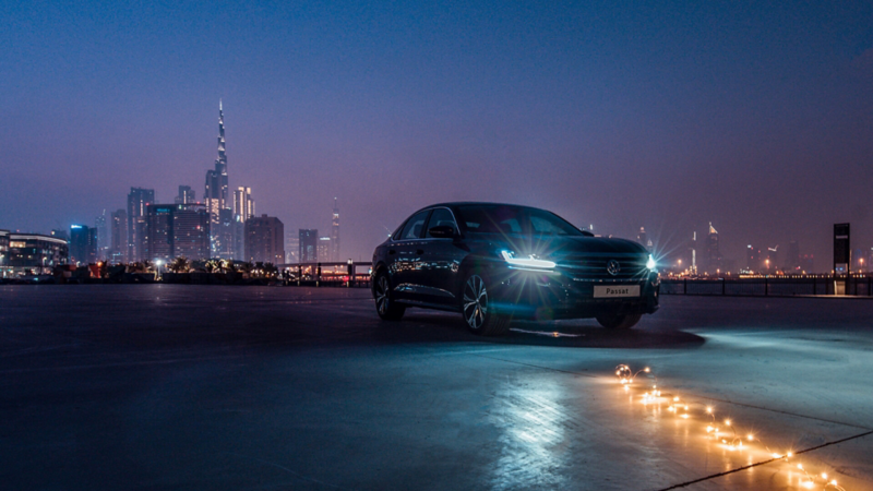 The 2020 Volkswagen Passat parked outside a city, a row of lights lay on the floor in front of it