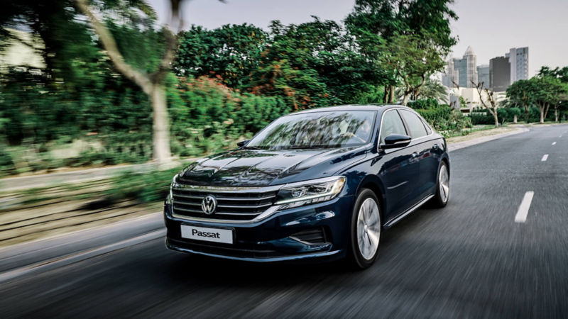 The Volkswagen Passat in Dubai driving down a road full of trees