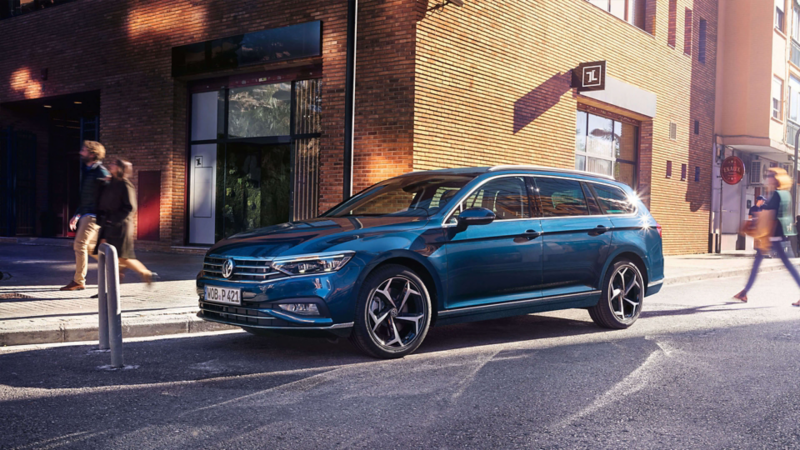 Ein blauer Passat steht vor einem Haus auf einem Parkplatz