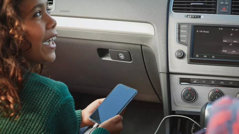 Happy child using phone connected to a VW infotainment system
