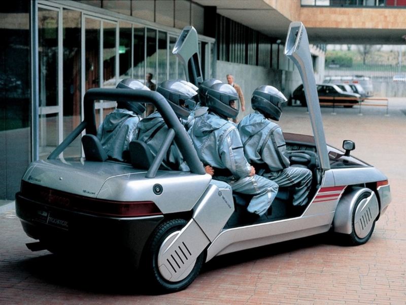 El Italdesign Machimoto 1986 está estacionado con cinco hombres en el interior, mostrando vistas trasera y lateral. 