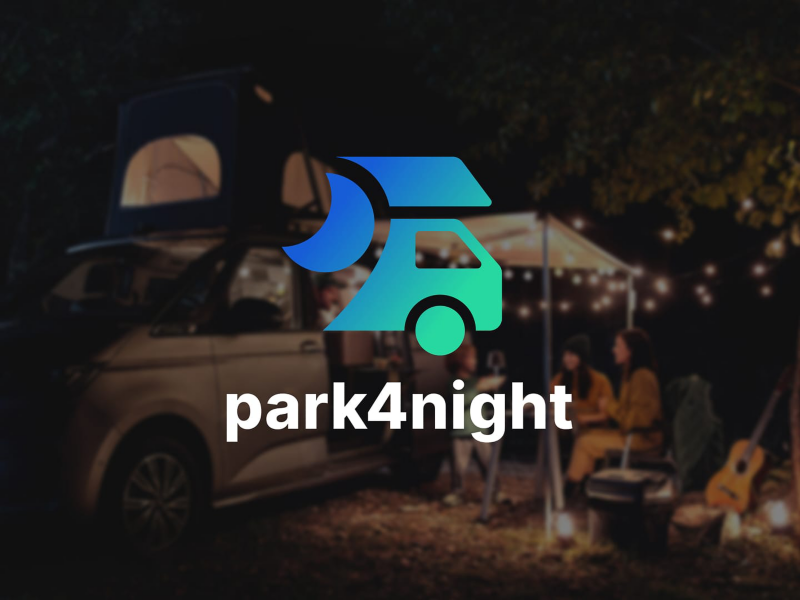 Una caravana aparcada en la noche con el logo de park4night encima