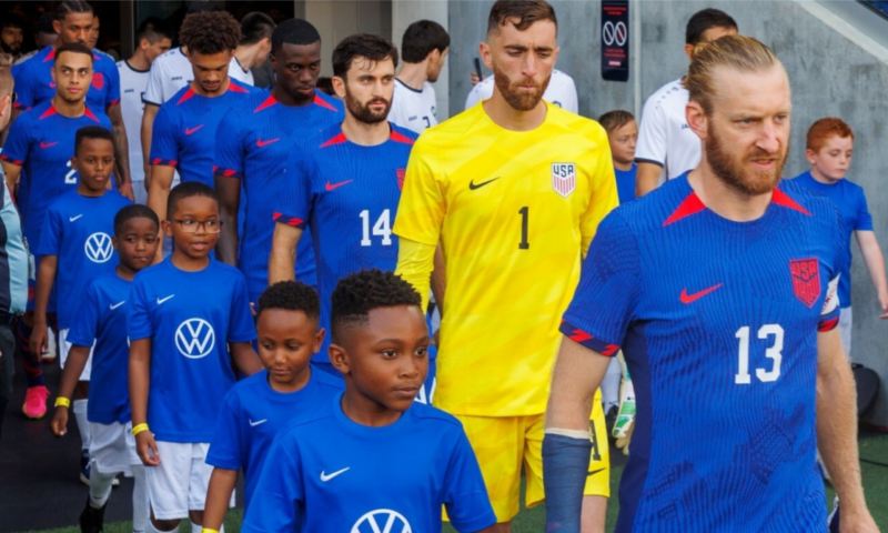 Youth players walk out alongside the U.S. players at the start USSF friendly.