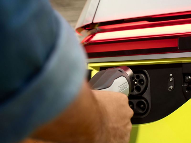 Un uomo mette in carica, presso una Wallbox, un ID. Buzz Volkswagen, con dettaglio sulla "spina Mennekes".