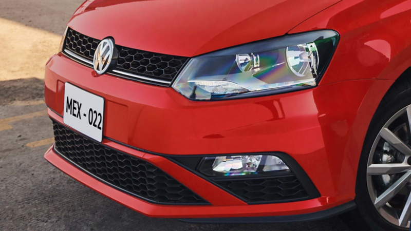 Polo Volkswagen de color rojo. Vista a parrilla frontal y luces delanteras. 