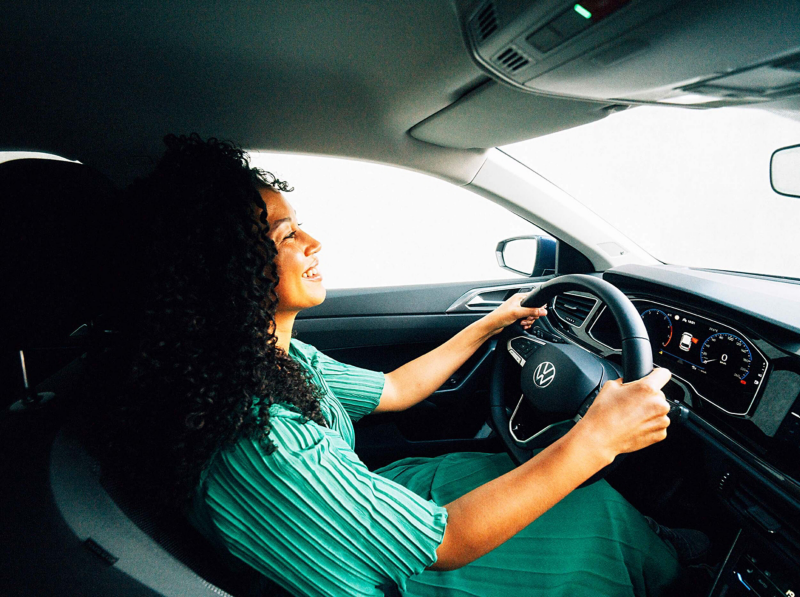 A woman driving a Volkswagen Polo