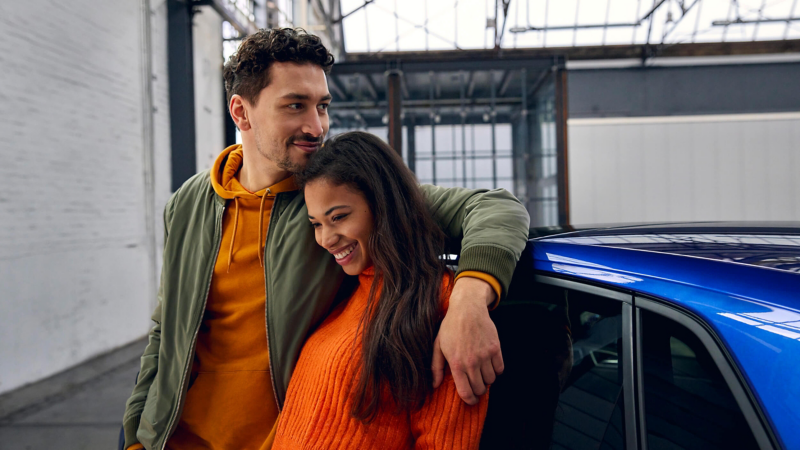 A man with his arm around a woman leaning on the Polo