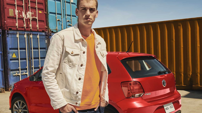 Polo VW en color rojo con chico al frente.