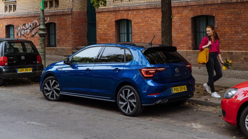 Polo tussen 2 auto's ingeparkeerd en een vrouw die bij haar polo wegloopt