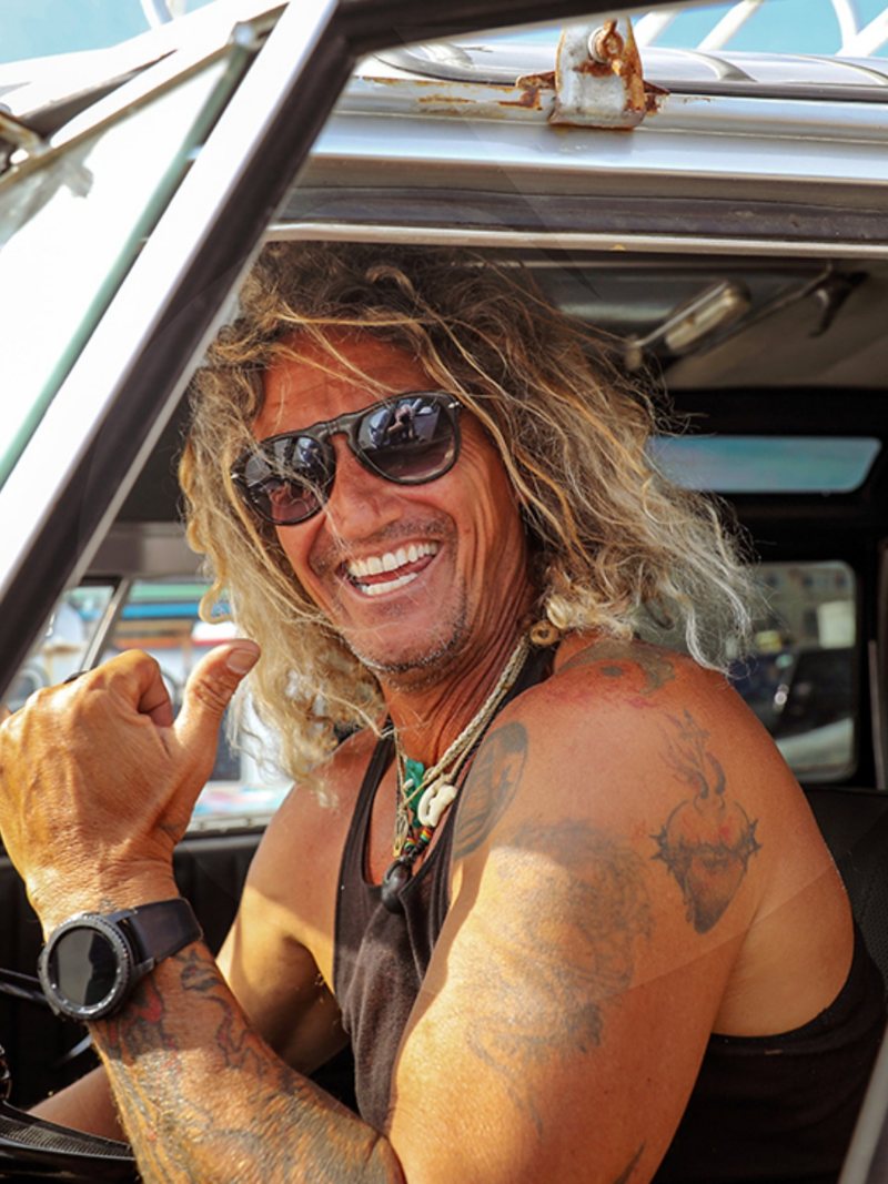 Surferen Martin sidder bag rattet i sin California og møder os med et smil.