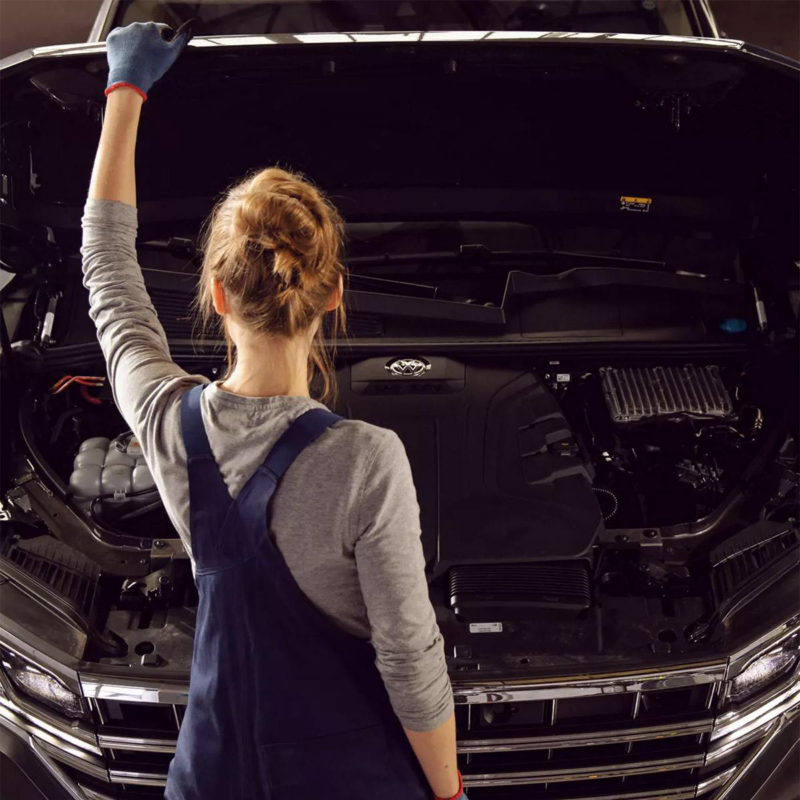Técnica de Volkswagen revisa el motor de una camioneta SUV. 