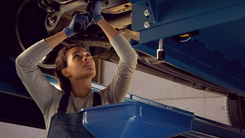 Técnica de Volkswagen revisa averías en la plataforma de un carro Volkswagen. 