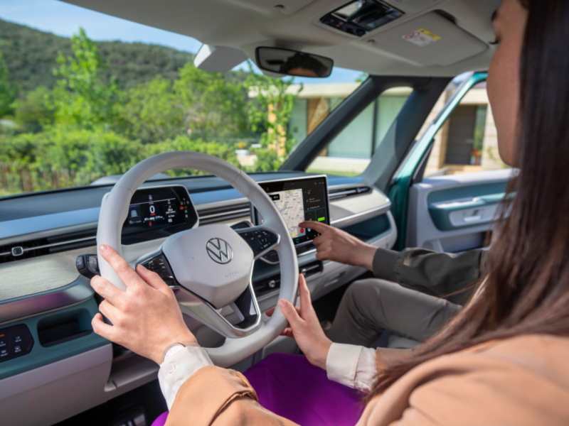 Una mujer sujetando el volante de un vehículo VW. 