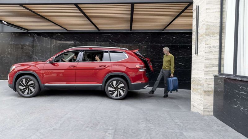 Hombre con maleta coloca el pie en el sensor de apertura de cajuela de Volkswagen Teramont.