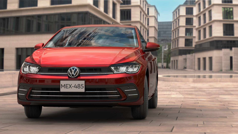 Volkswagen Polo 2024 en color rojo dentro de una ciudad moderna. 