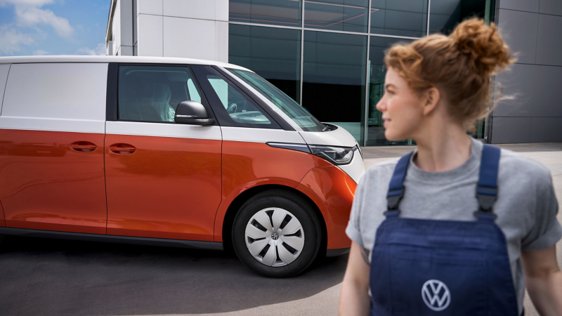 Photo showing a VW technician standing in front of an ID. Buzz Cargo. 