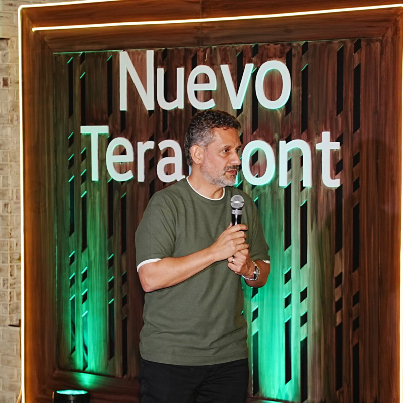 Directivo de Volkswagen participa en la presentación de Nuevo Teramont frente a un escenario con luz verde.