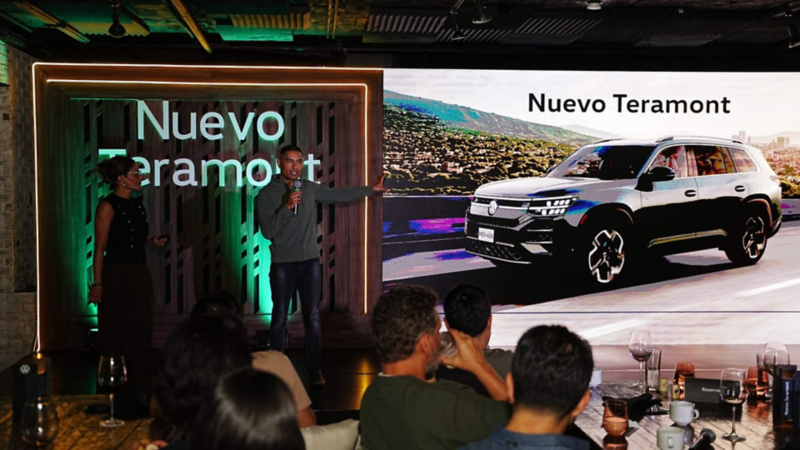 Dos anfitriones presentan Nuevo Teramont ante el público, con el vehículo proyectado en una pantalla.