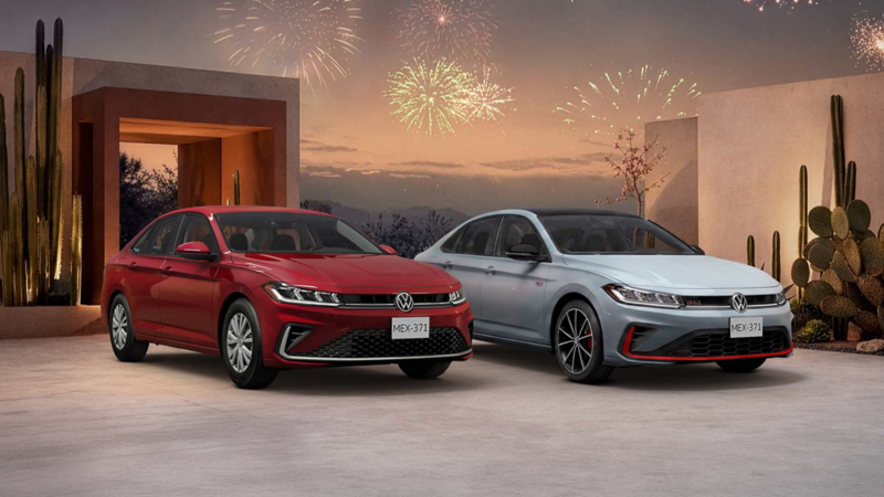 Dos sedanes Jetta, uno rojo y otro plateado, frente a cactus y fuegos artificiales al atardecer.