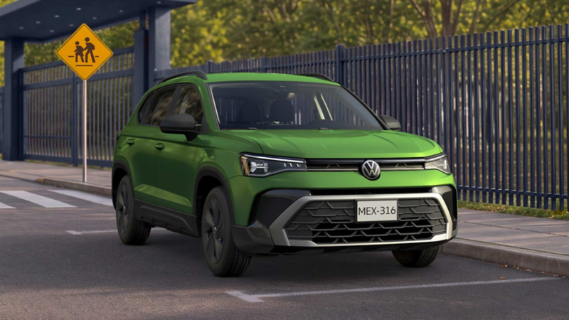 Volkswagen Taos de color verde circula sobre una calle cercano a una banqueta. 