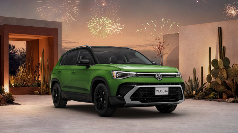 SUV Taos verde con detalles negros, cactus y fuegos artificiales al atardecer.