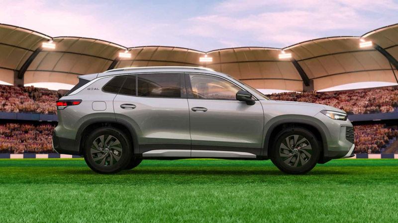 SUV Tiguan GOAL gris de perfil frente a un estadio iluminado y lleno de público.