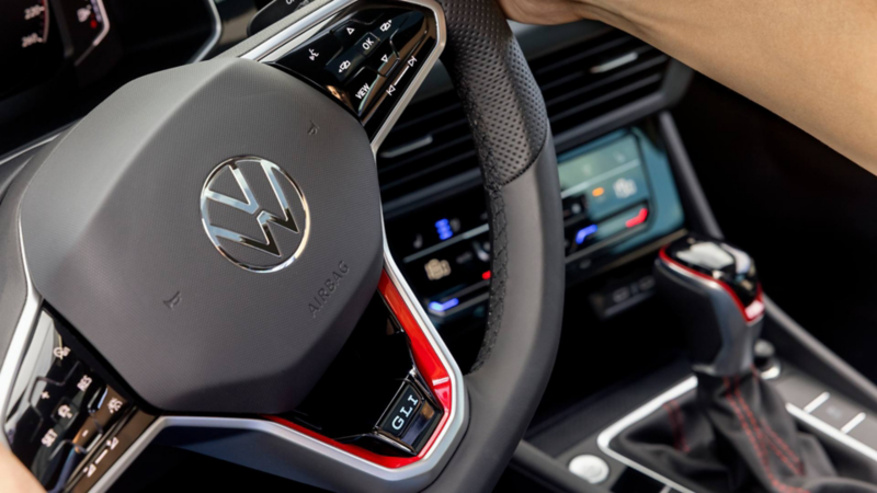 Volante multifunciones con detalle rojo de Jetta GLI 2026. Logo Volkswagen y controles integrados.