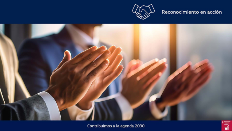 Dos hombres vestidos con traje aplauden a una presentación. 