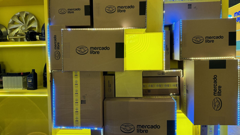 Cajas de Mercado Libre y estante amarillo con algunas piezas de autos Volkswagen.