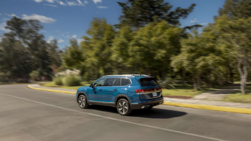 Camioneta de Volkswagen color azul circula en una avenida cercana a un parque.