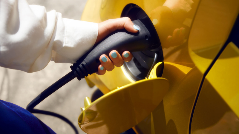 A person plugging their electric car in to charge