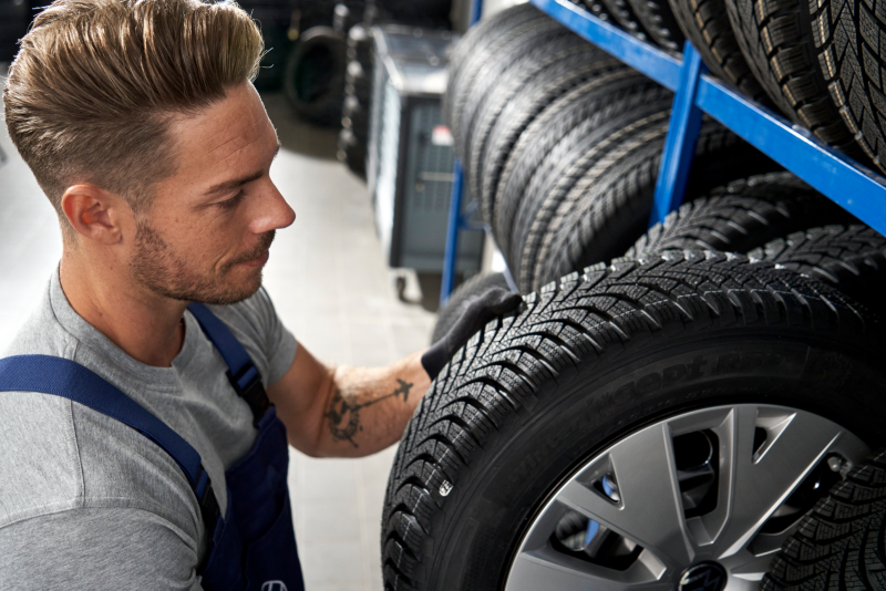 Un employé Volkswagen prend une roue dans un rack