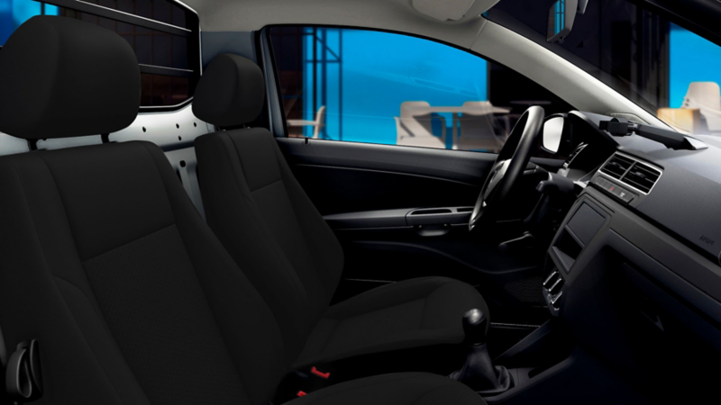 Interior de camioneta pick up seminueva de Volkswagen, con dos asientos forrados en tela negra.
