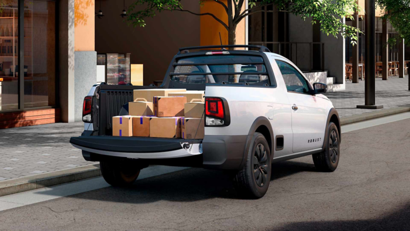 Volkswagen Saveiro 2025 en color exterior blanco carga varias cajas en la batea. 