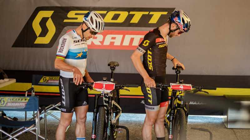 due mountain biker in piedi accanto alle loro biciclette