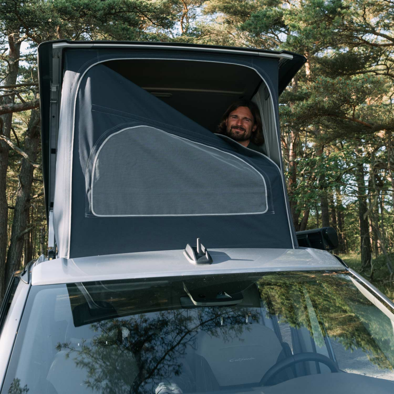 Sebastian kikar fram i popup-tältet på taket på VW California.