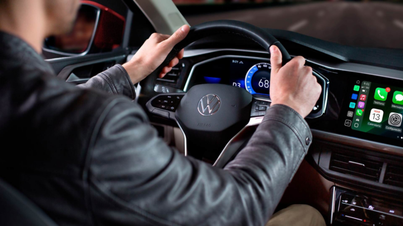 Conductor al volante de un Volkswagen Virtus con la pantalla central encendida.Modificado con inteligencia artificial