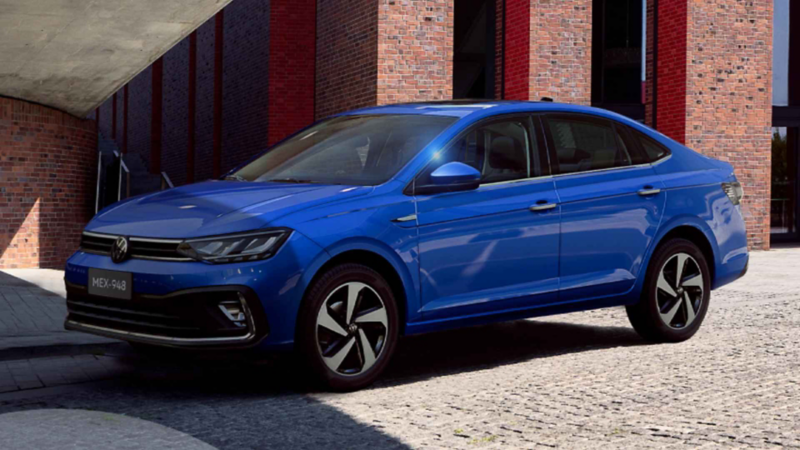Volkswagen Virtus 2024 en color azul, afuera de un edificio de ladrillos.