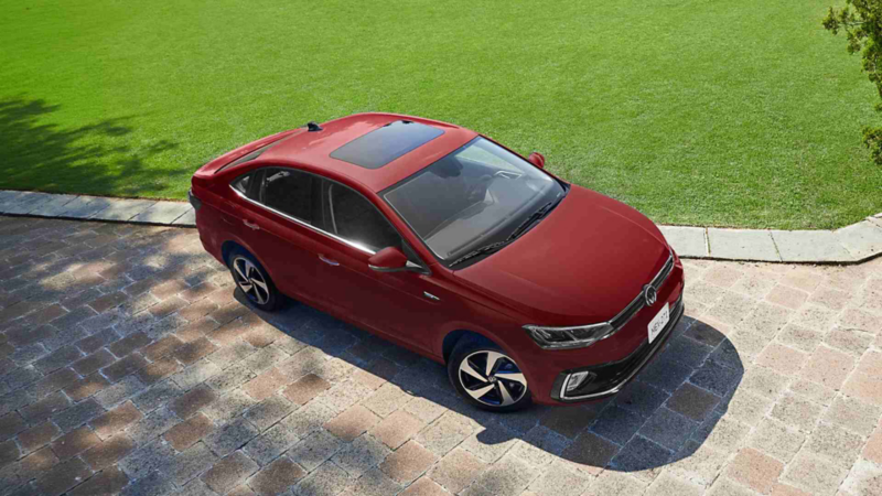 Volkswagen Virtus rojo visto desde arriba, estacionado junto a una zona de césped.