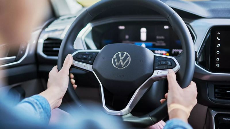 Conductor de un auto Volkswagen toma volante multifunciones.