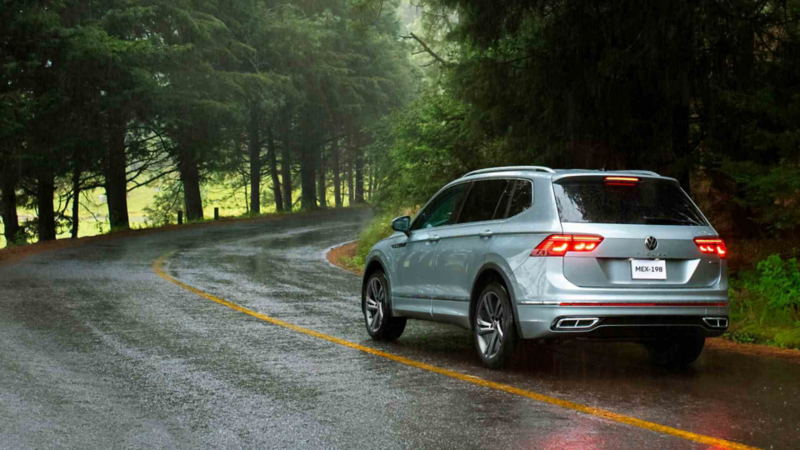 Camioneta Tiguan en carretera húmeda dentro del bosque.
