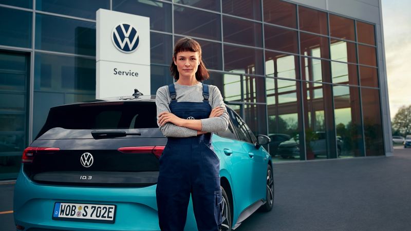 Une collaboratrice du service entretien VW se tient devant une VW ID3