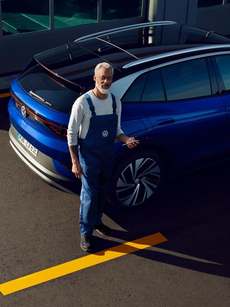 Un collaborateur du service entretien VW se trouve devant l’atelier – Entretien VE VW