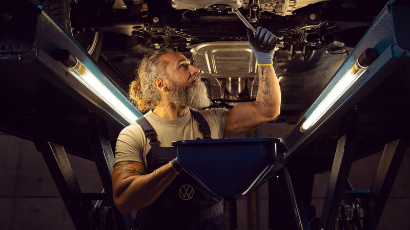 Mechanic inspecting car on ramp