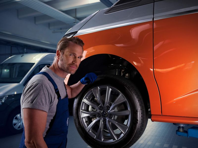 A VW technician inspecting a tyre